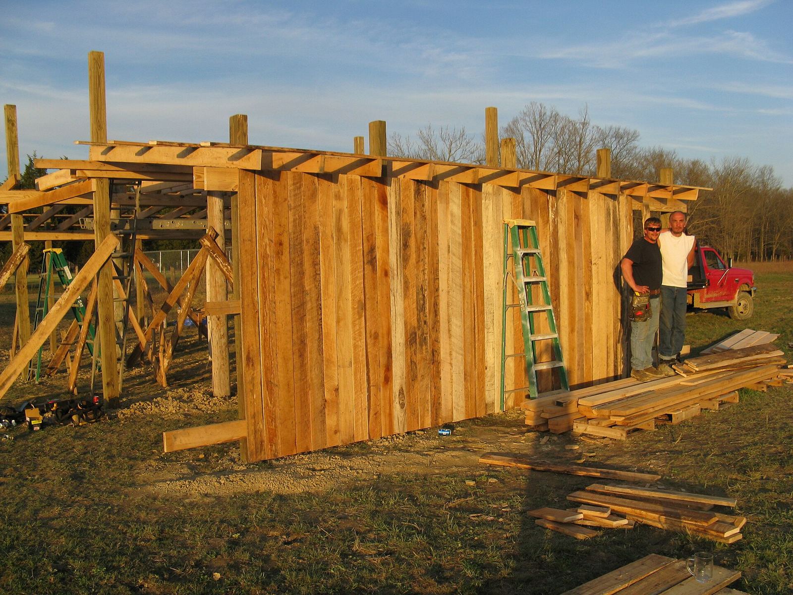 Pole barn under construction with posts and roof trusses set
